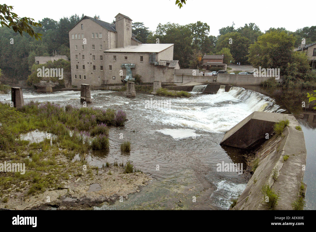 Reflection of an old building over calm waters in a river at Elora Ontario Canada Stock Photo