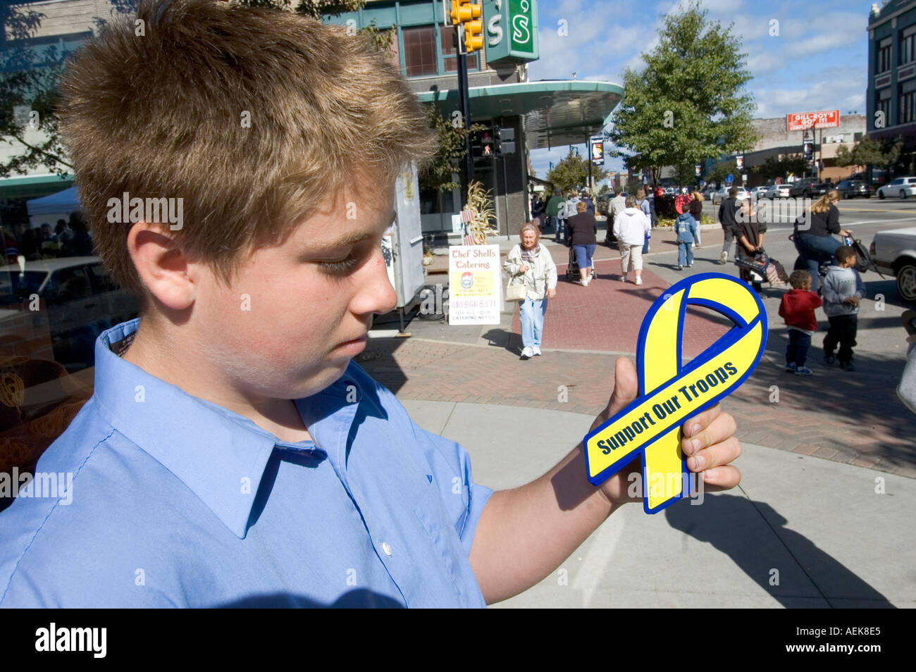 Teen boy sells magnetic save our troops ribbons to raise money for a