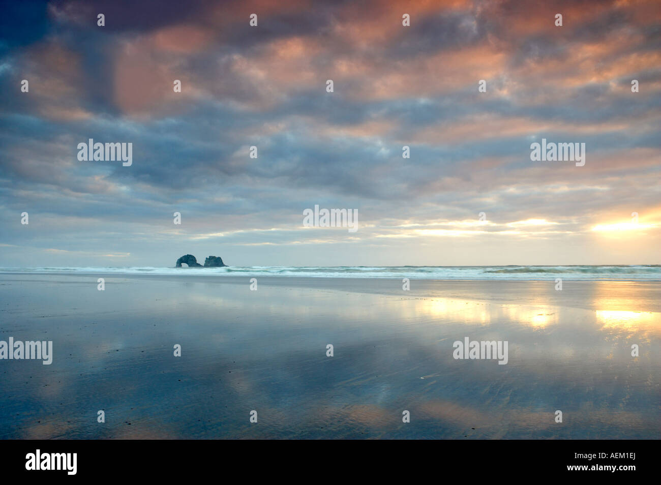 Low tide reflection with sunset and arch Rockaway Beach Oregon Stock