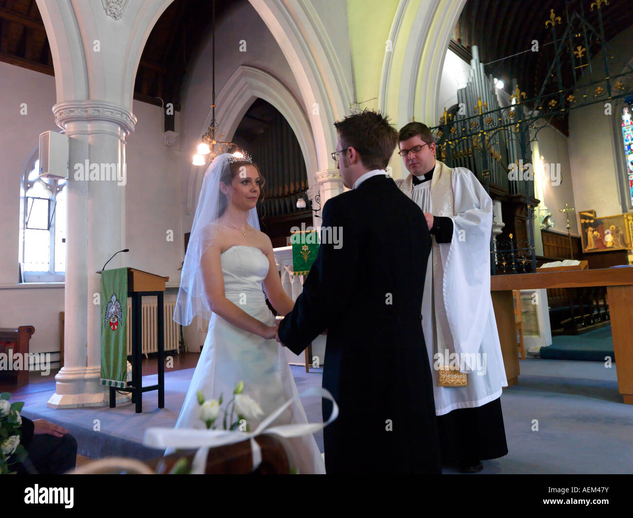 Exchanging Vows During an Anglican Wedding Service Stock Photo