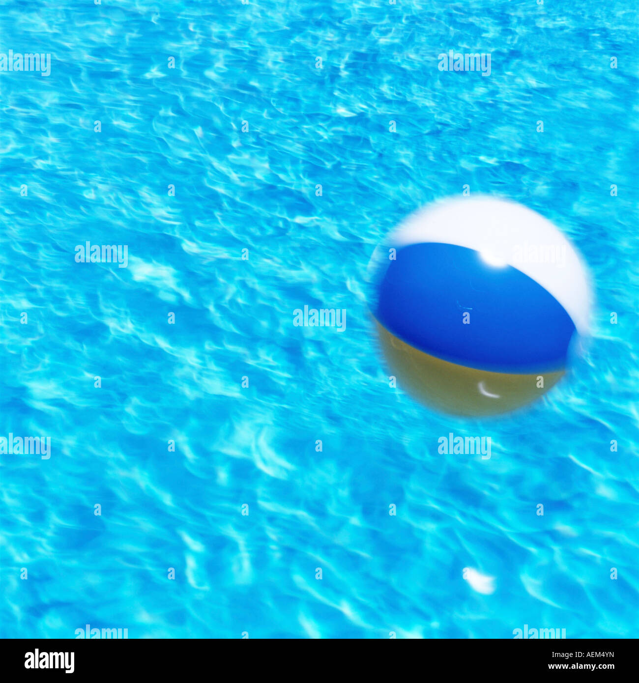 beach ball being blown across a swimming pool Stock Photo