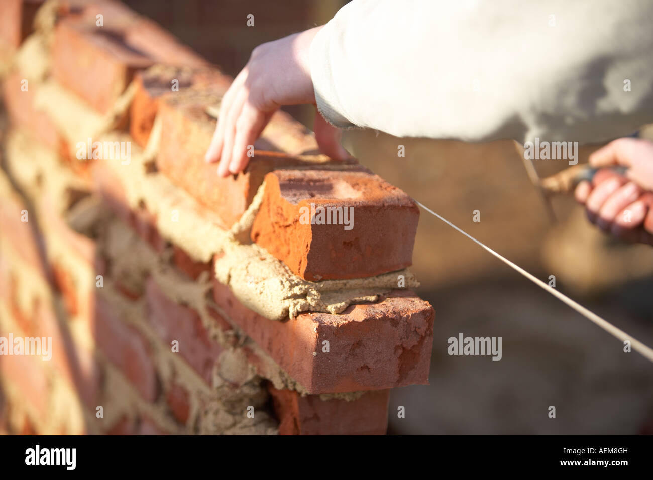 WORKER  LAYING BRICKS WITH MORTER ON A CONSTRUCTION SITE IN THE UK, BUILDING A HOUSE Stock Photo
