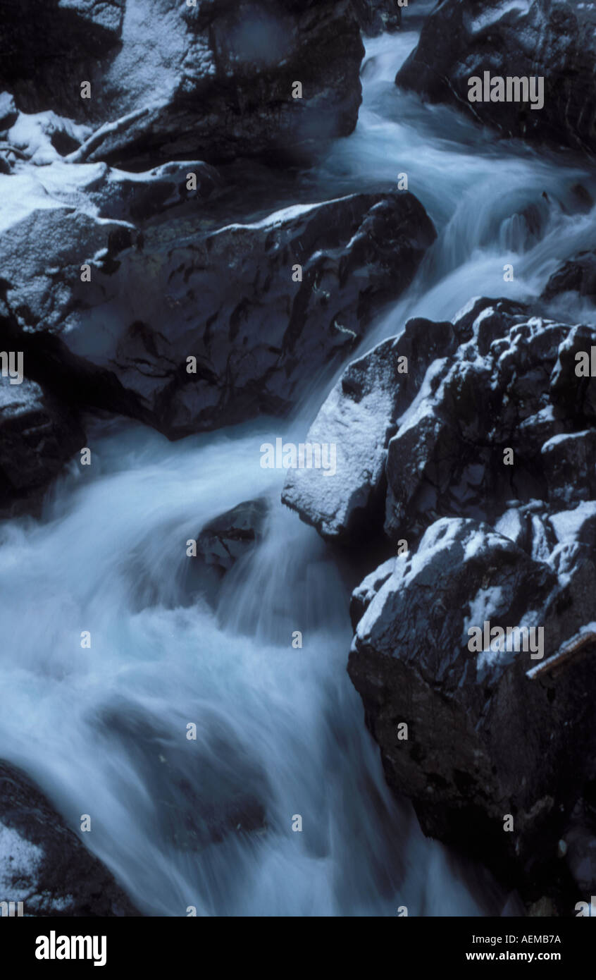 Water of creek running through rock boulders in Klus at Kandersteg Bernse Alps Oberland Switzerland Stock Photo