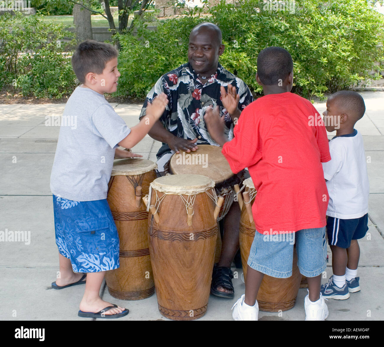 Children playing drums with Jamaican performer Stock Photo Alamy