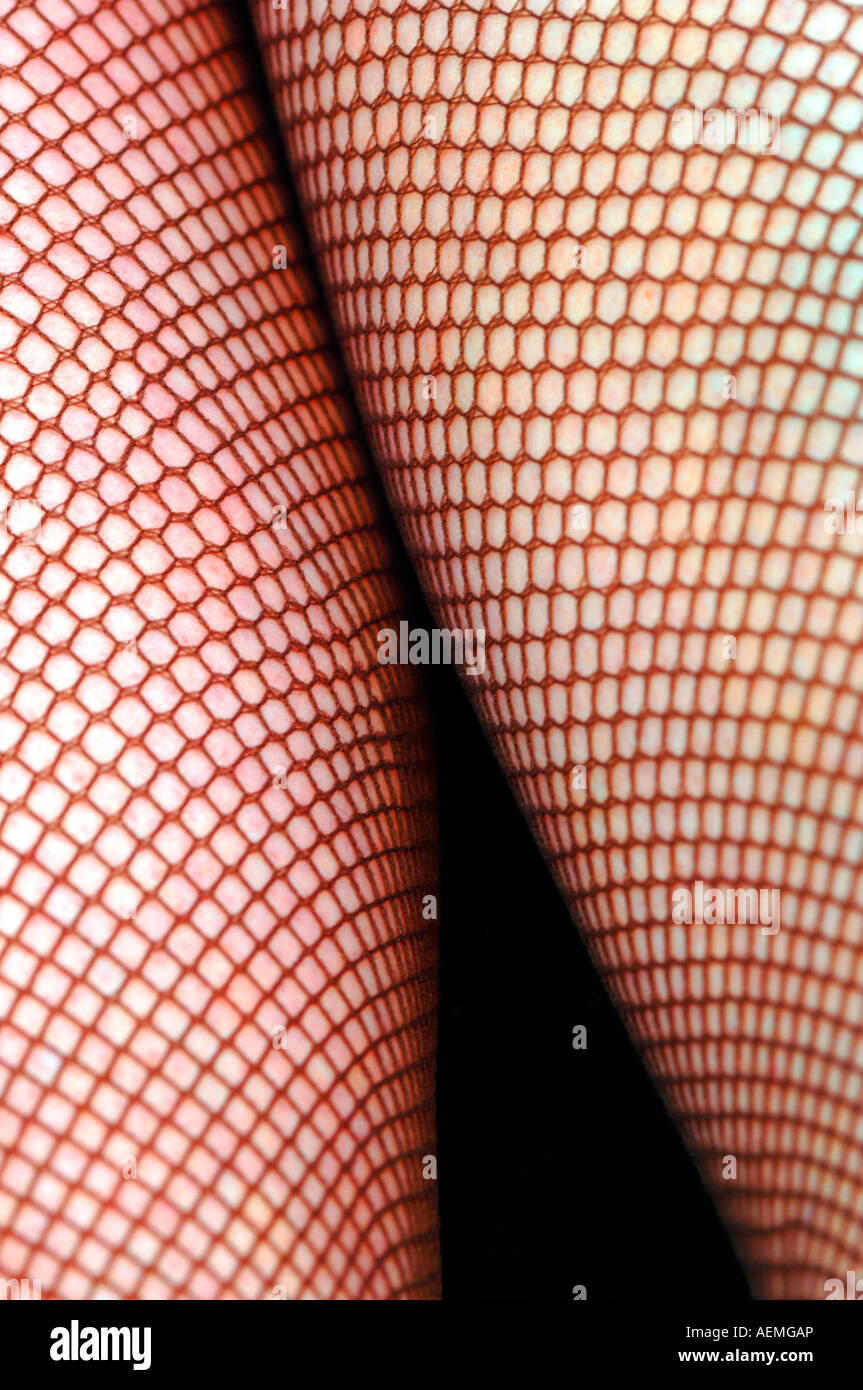 Womans Legs In Fishnet Tights. Stock Photo