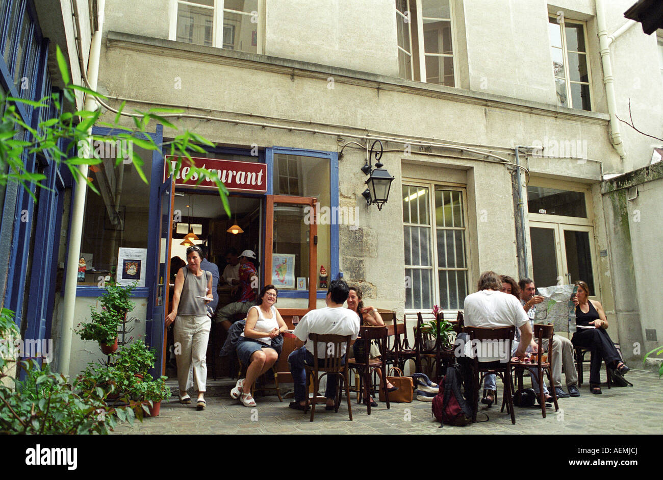The outside seating terrace in the back yard. Wine bar les Enfants Rouges in Paris. Paris, France. Stock Photo
