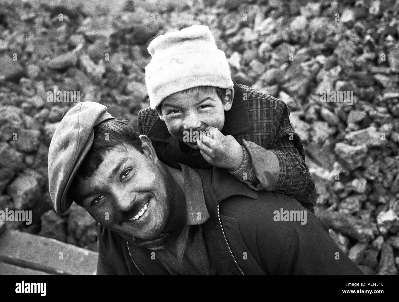 Father and Daughter from Kashgar having fun in front a pile of coal,  Xinjiang Province China Stock Photo