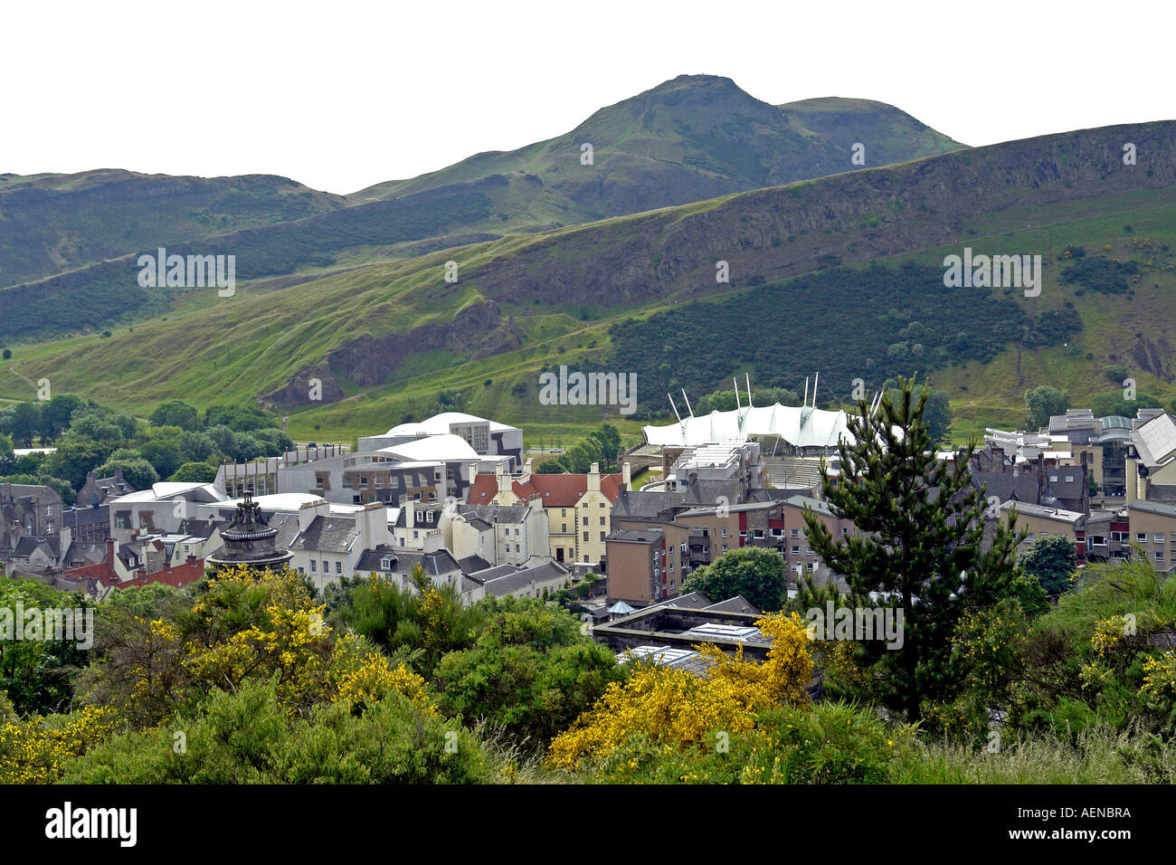 Arthurs Seat towering over the east end of Edinburgh with The Scottish Parliament to the left and Dynamic Earth right. Stock Photo