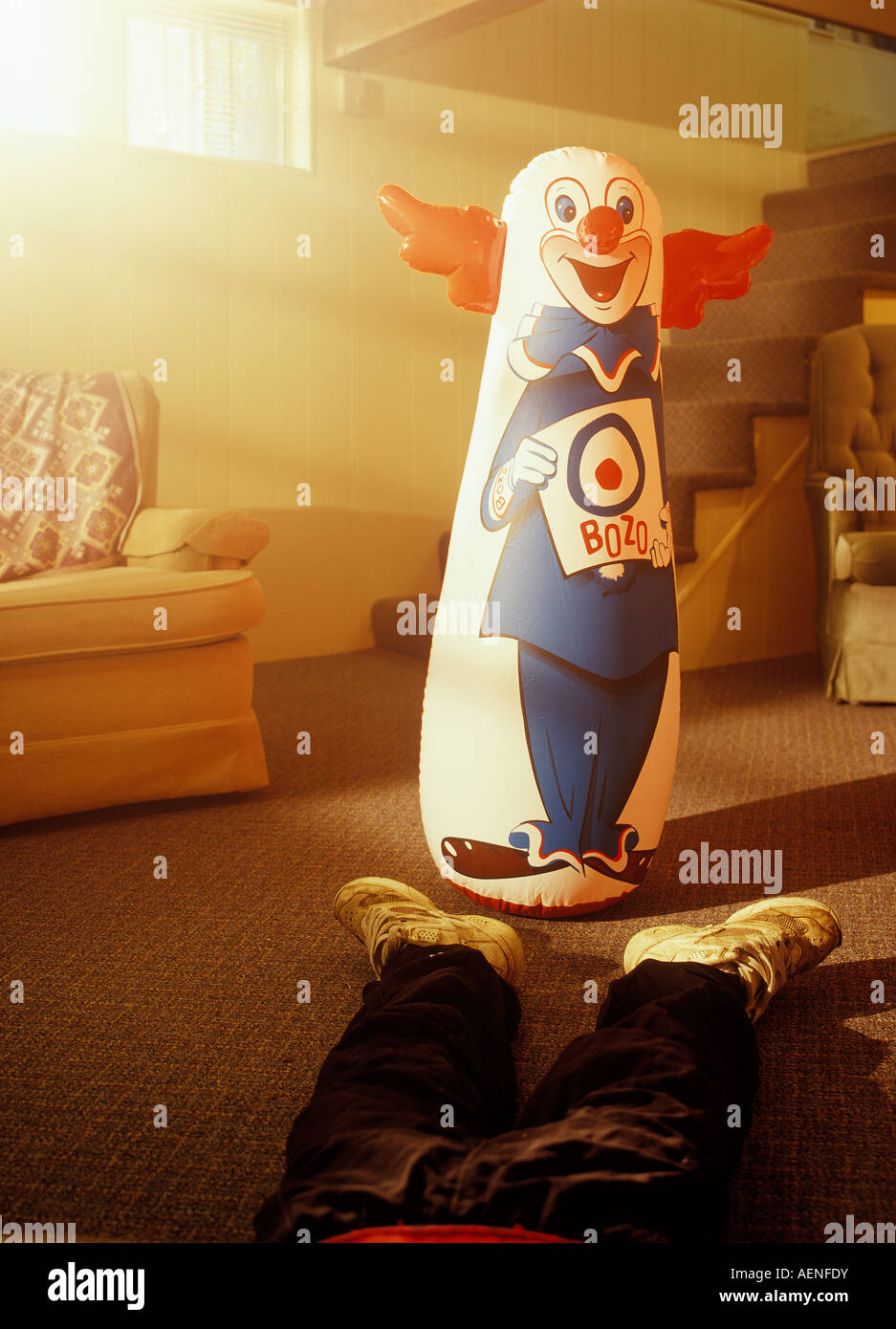 A young boy passed out in front of a bozo the clown punching bag Stock Photo