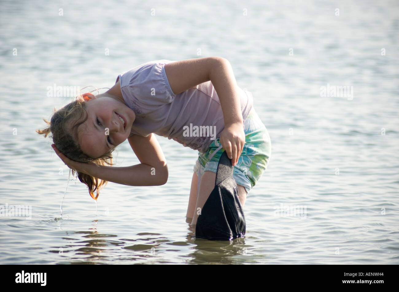 wetting little A happy smiling Young girl wetting her hair in the sea , summer Stock Photo  - Alamy