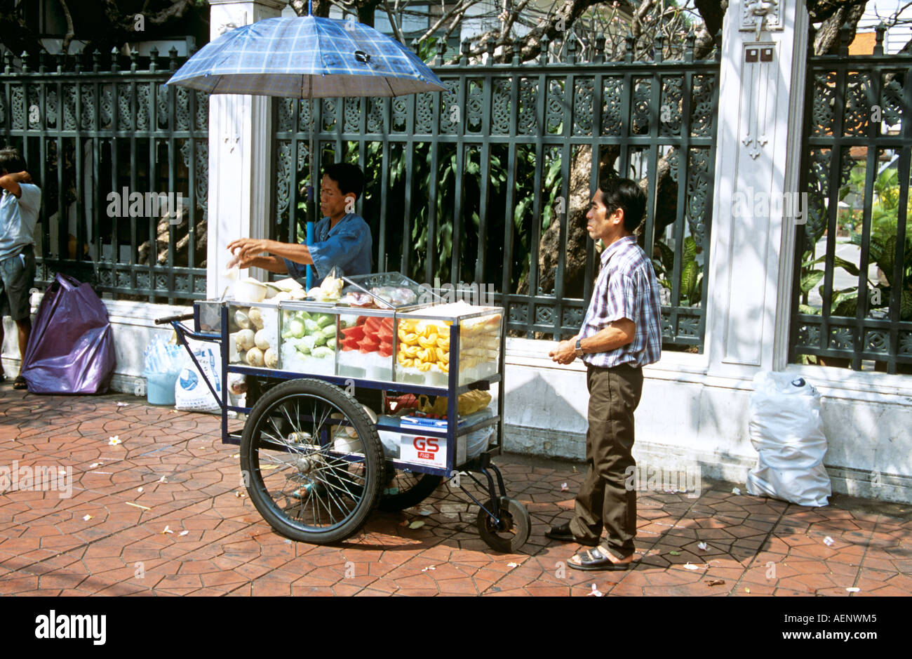Street vendors selling fresh chilled fruit from mobile market stall