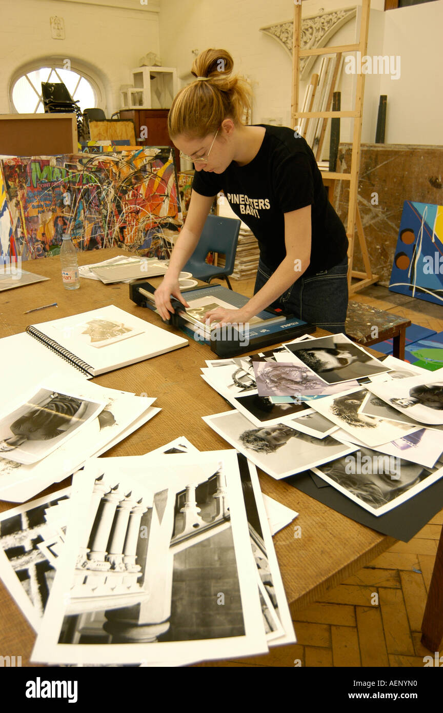 Female woman art student photographer mounting prints in her studio at