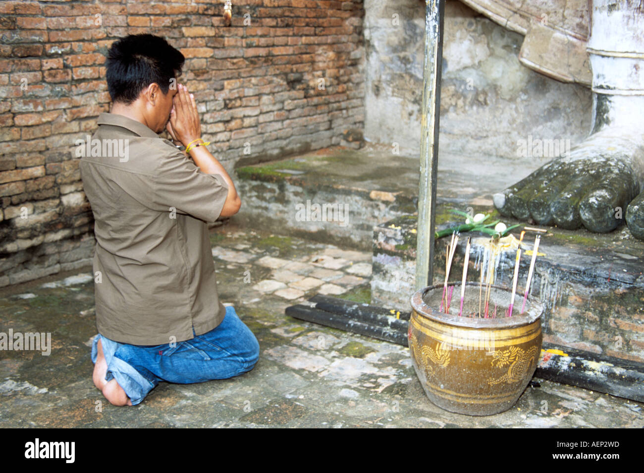 Worshipper praying, Wat Mahathat, Sukhothai Historical Park, Sukhothai, Thailand Stock Photo