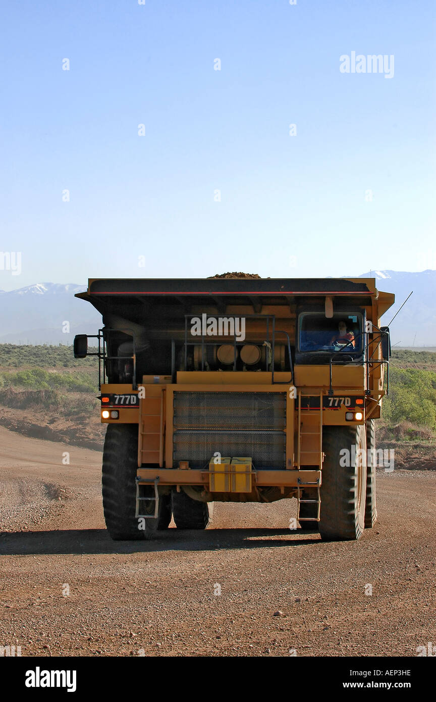 A huge dump truck drives down a dirt road close up Stock Photo - Alamy