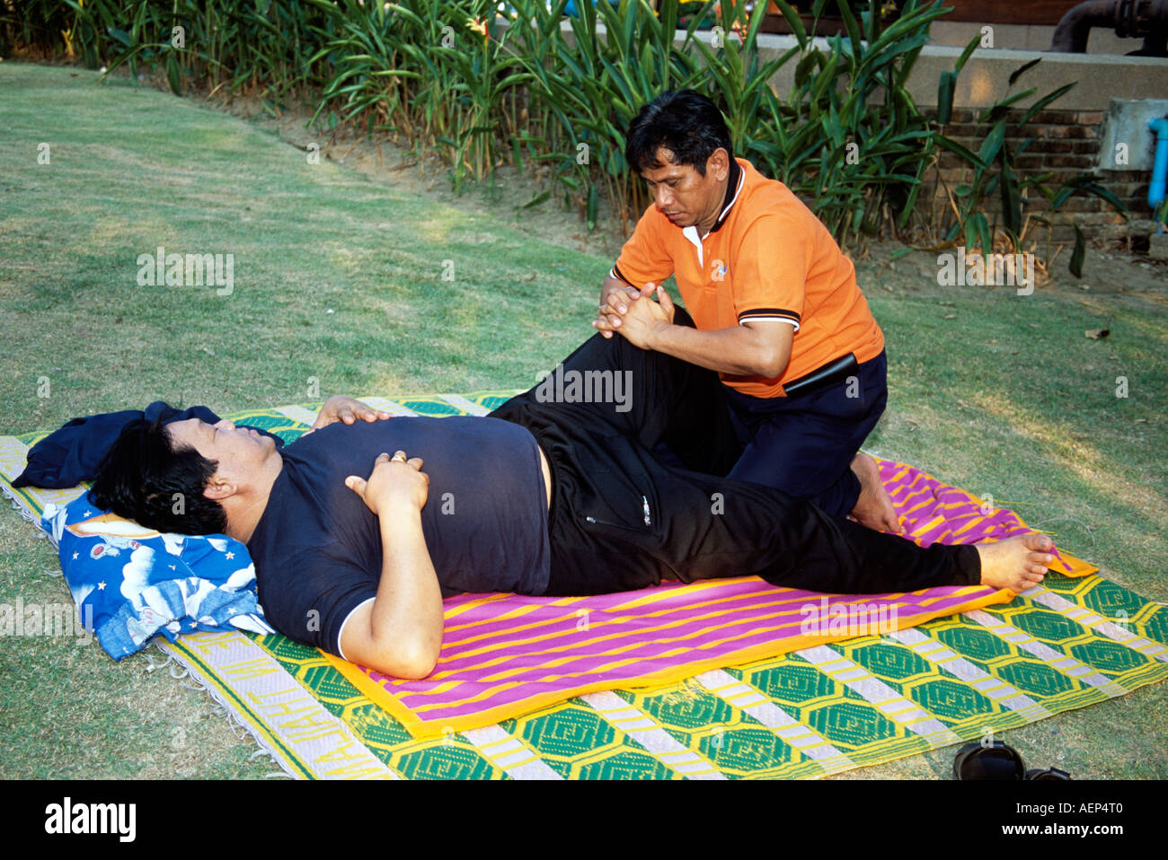 Man having a massage in the open air by a masseur, Phitsanulok, Thailand Stock Photo