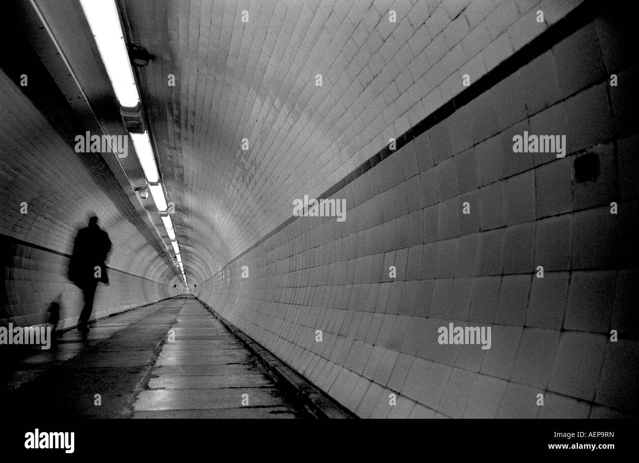 A man walks his dog through the Tyne Tunnel. Stock Photo