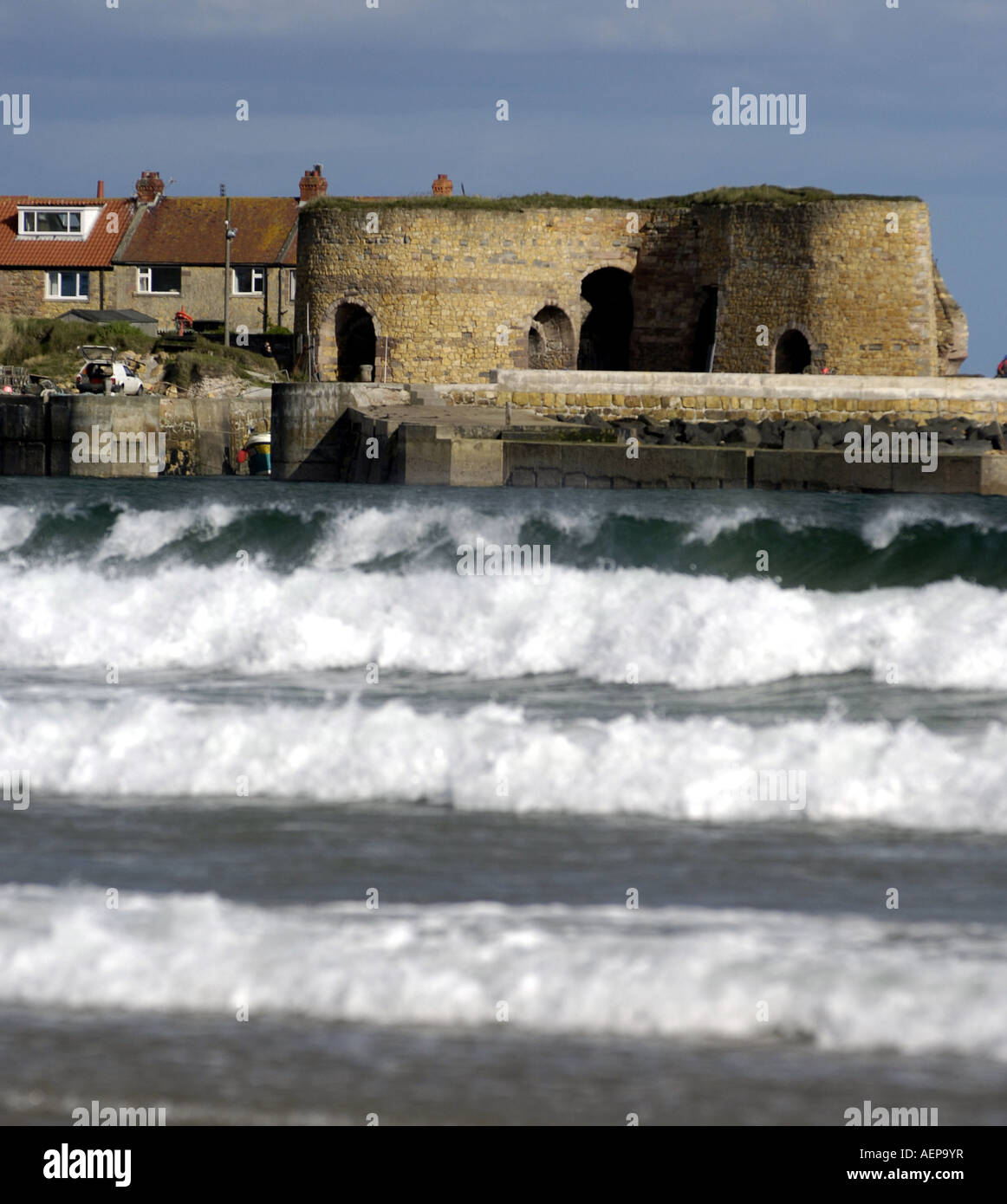 beadnall bay harbour Northumberland  with waves and harbour fort Stock Photo
