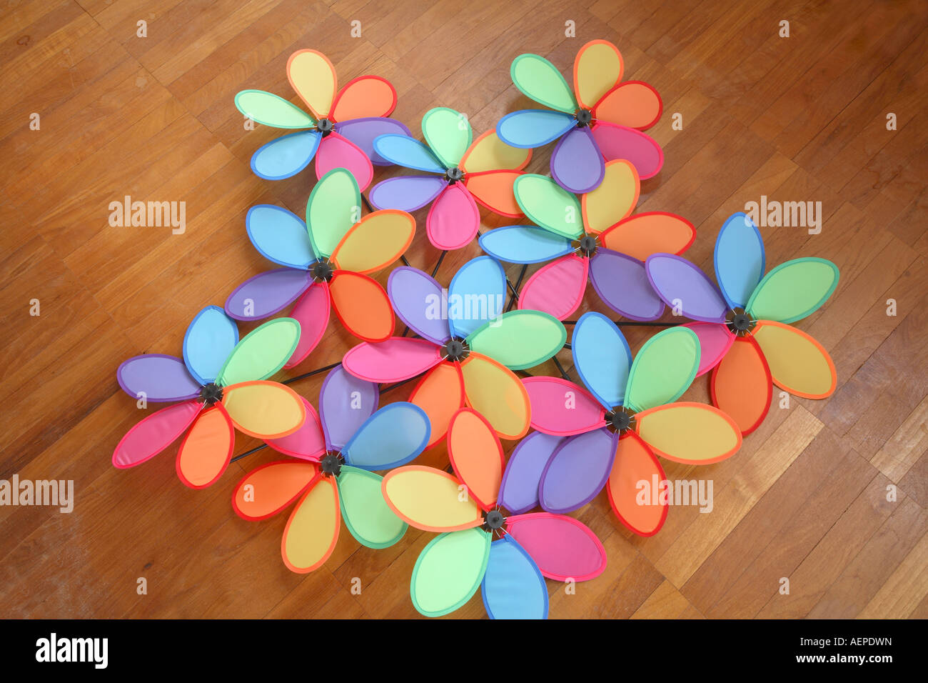 Mass Of Six Petaled Multi Colored Windmills Laying On Teak