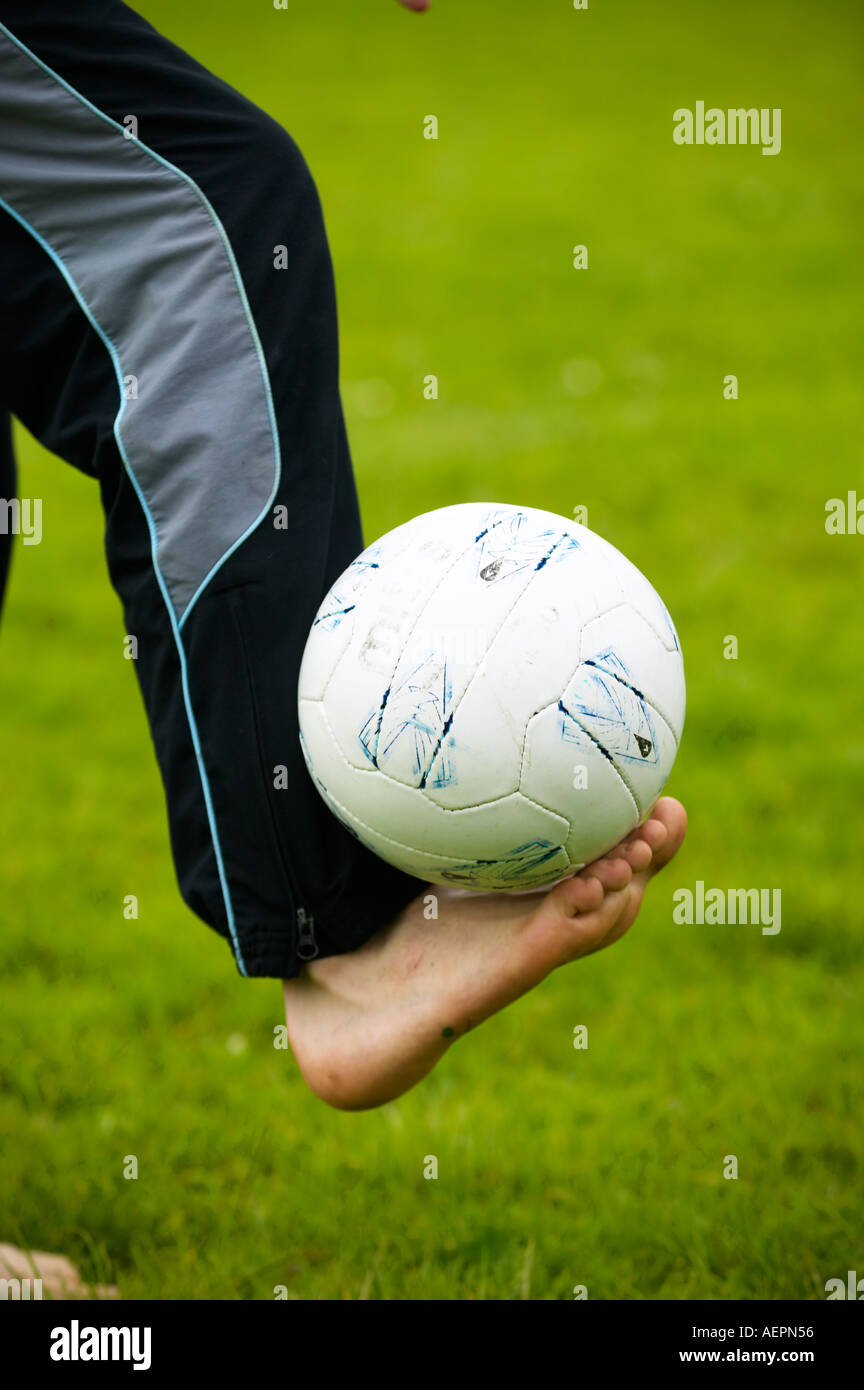 young boy balancing football on his bare foot Stock Photo Alamy