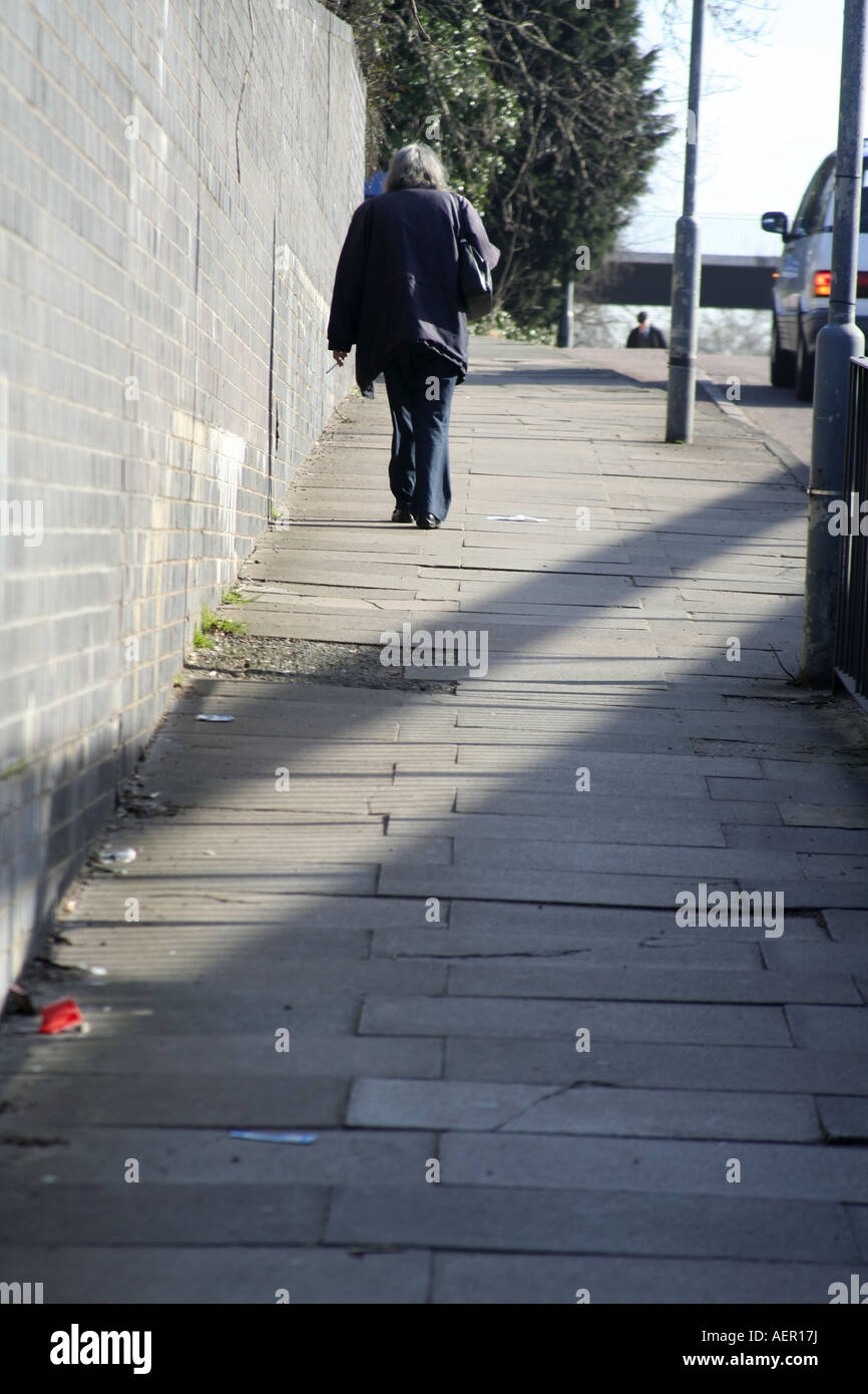 Woman walking alone in street hi-res stock photography and images - Alamy