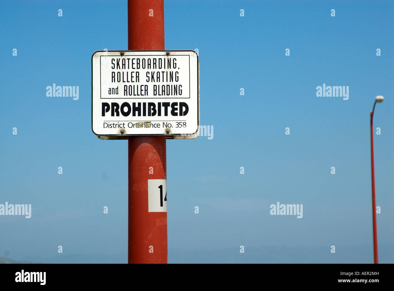 Sign skateboarding prohibited on red post against blue sky Stock Photo
