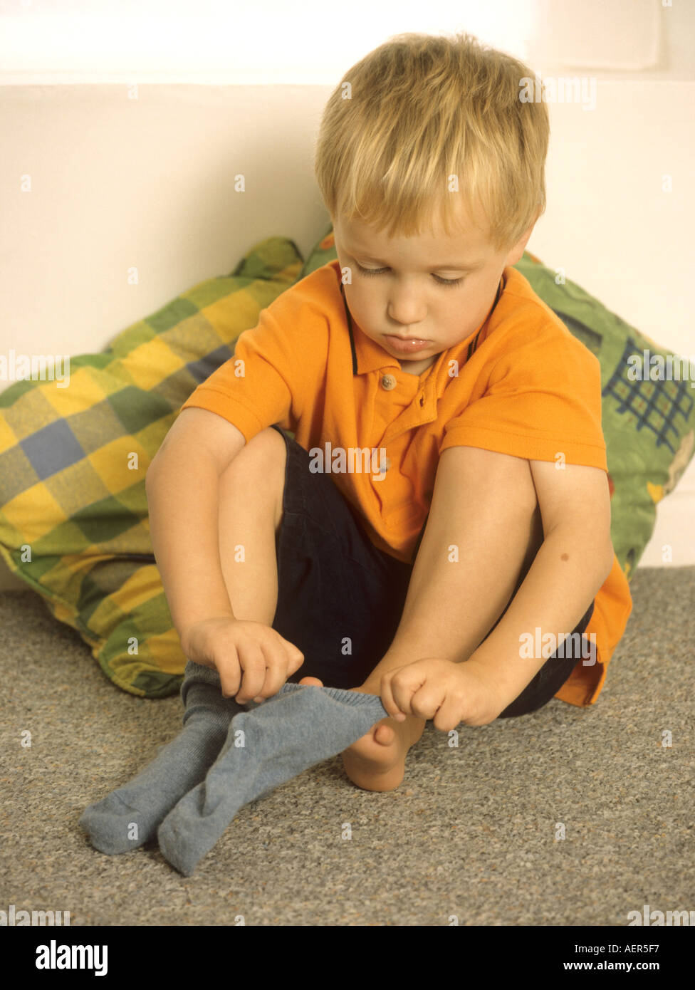 Young boy learning to dress himself Stock Photo Alamy