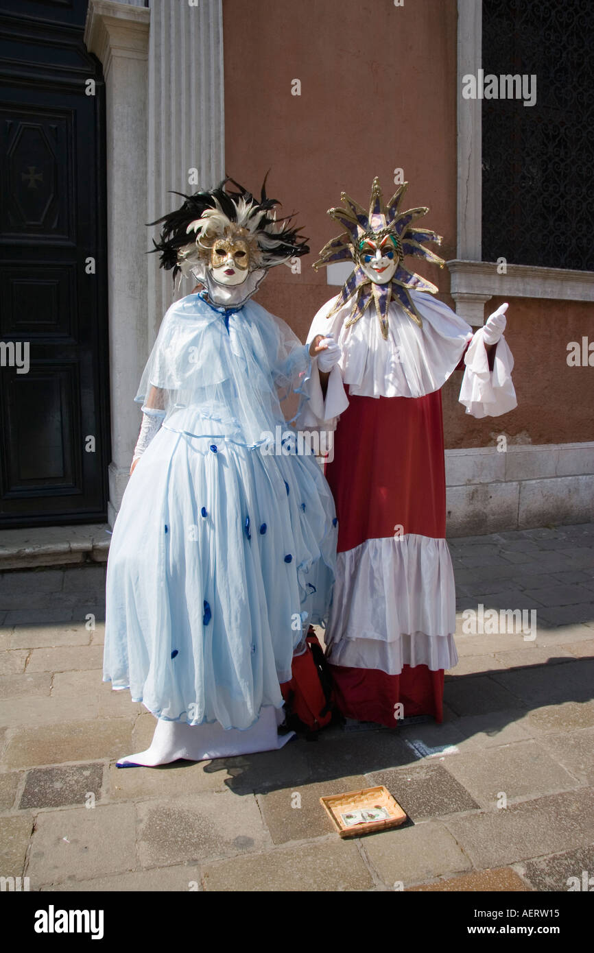 Couple wearing masks and traditional clothing near Campo San