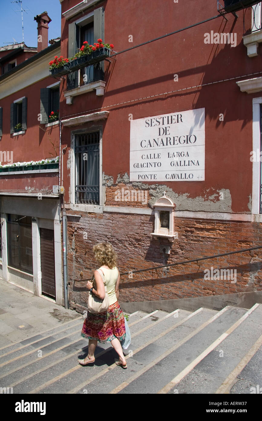 Woman walking down steps of Ponte Cavallo bridge over the Rio dei Mendicanti Venice Italy Stock Photo