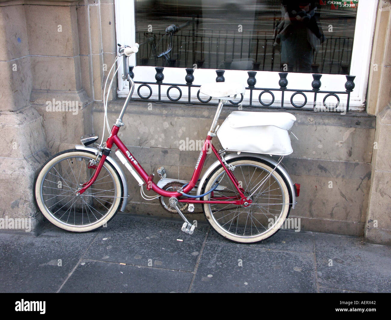 an old fashion ladies bike resting against a window captured whilst at