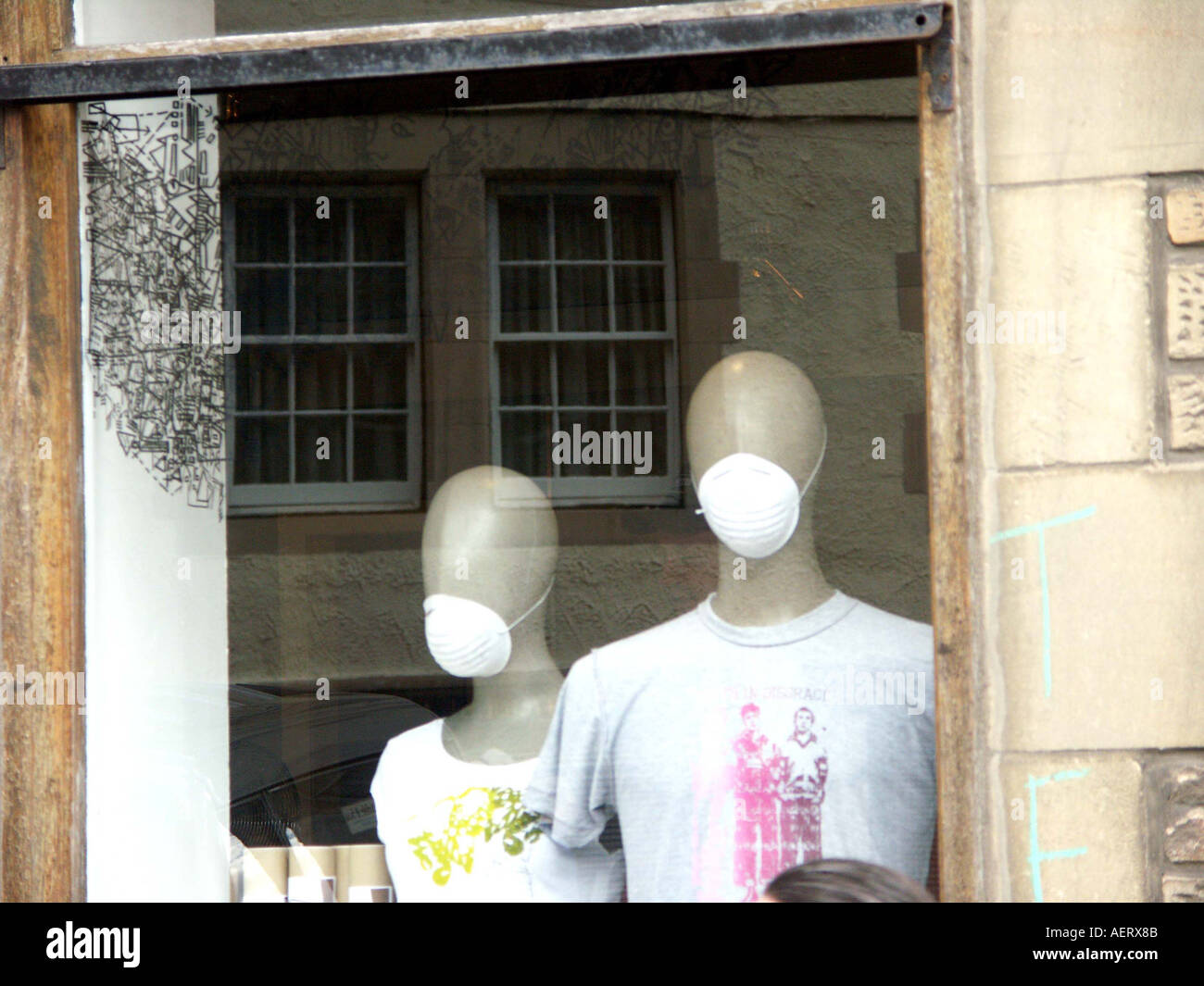 a creative window display of two bald dummies with masks at Analogue a chilled out book store 102 west bow in edinburgh scotland Stock Photo