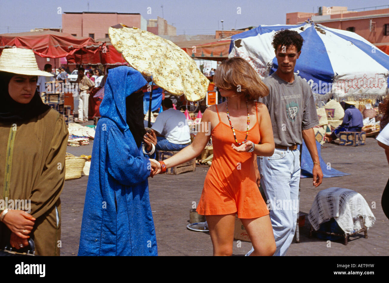 Morocco Marrakech Woman selling bracelet to tourist at square called Djema el Fna Stock Photo