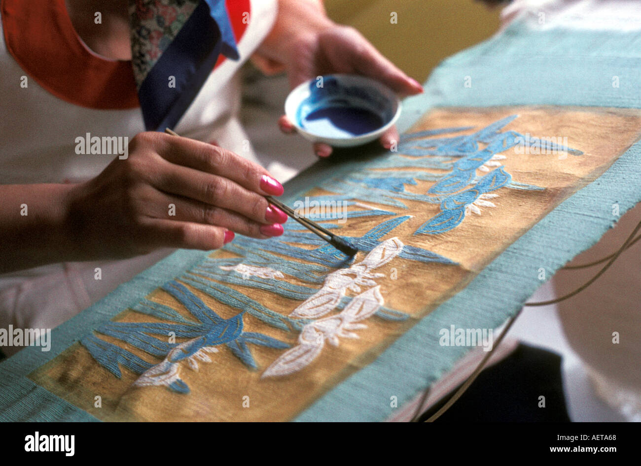 Okinawan craftswoman colouring a bingata wax resist dyed textile Stock Photo