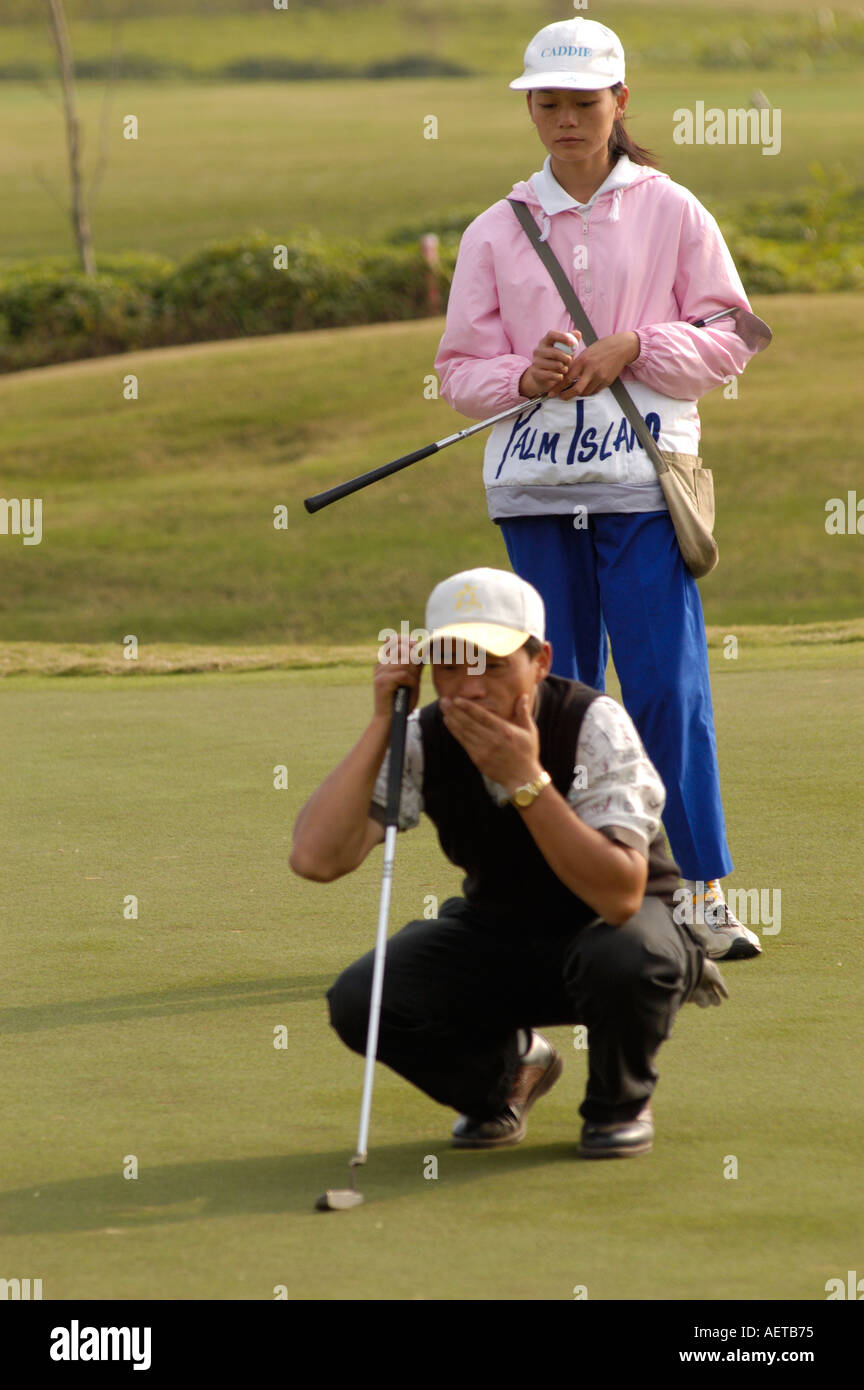 A Trainee golf caddy and player at a golf resort in Guangdong Province in China 2005 Stock Photo