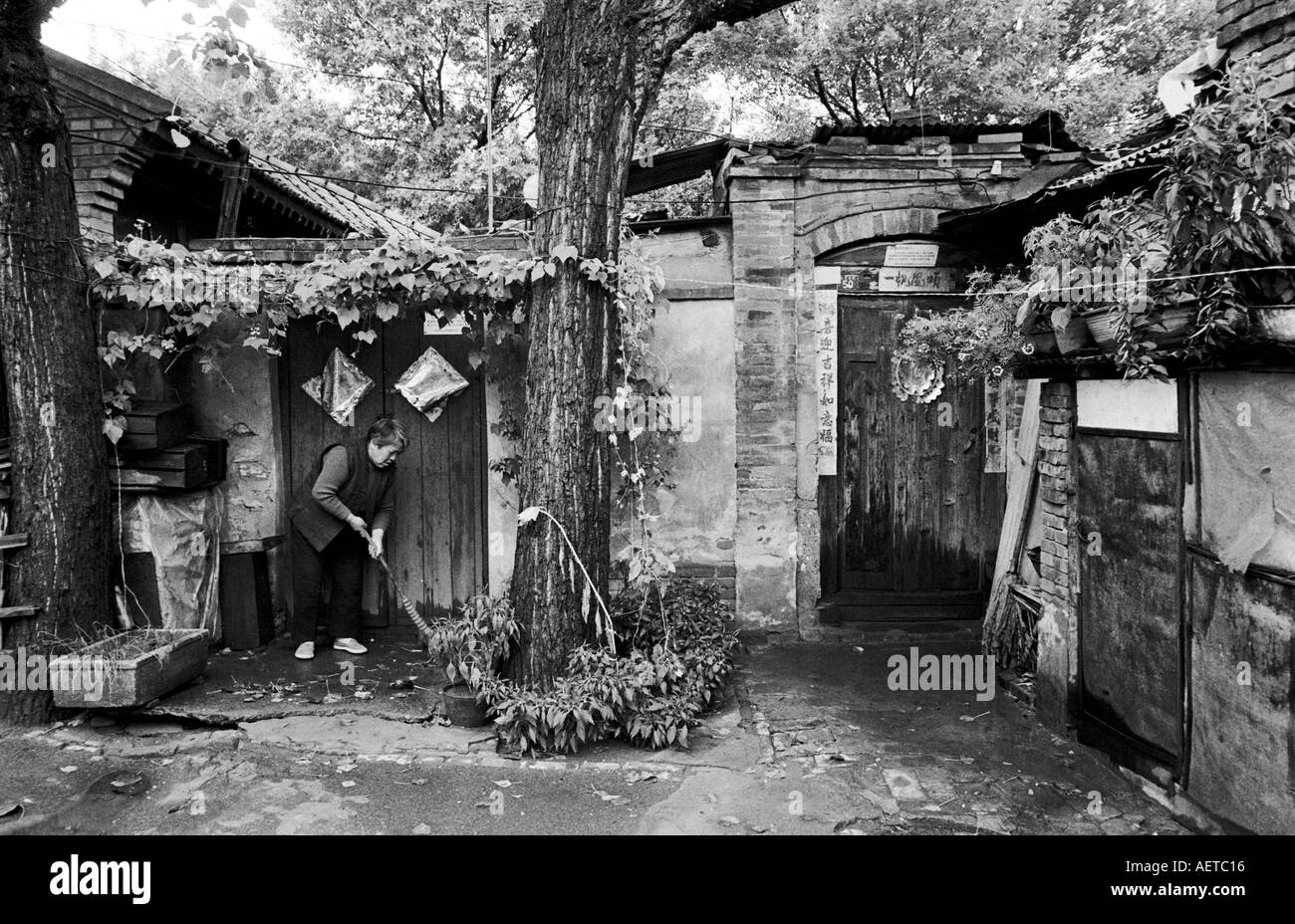 A lady sweeping her doorway in an old Beijing hutong 2003 Stock Photo