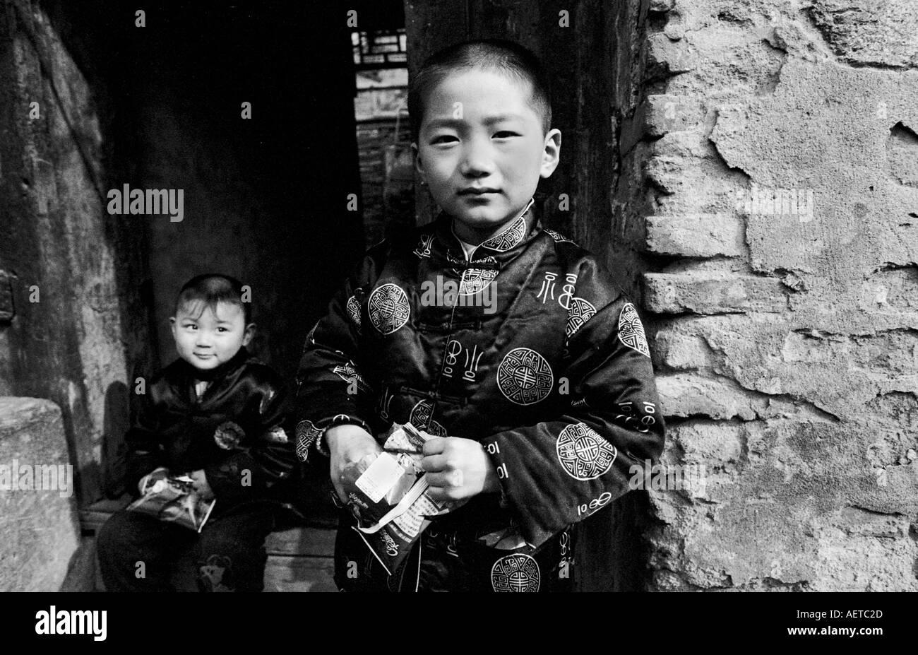 Two boys wearing traditional clothes at Chinese New Year in a Beijing hutong 2003 China Stock Photo