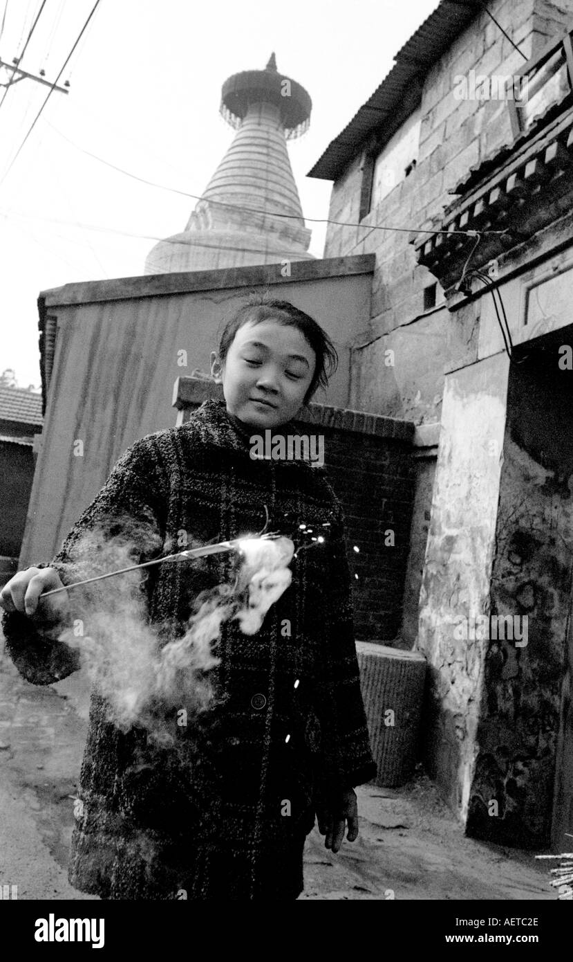 A girl with a firework at Chinese New Year in a Beijing hutong 2003 China Stock Photo