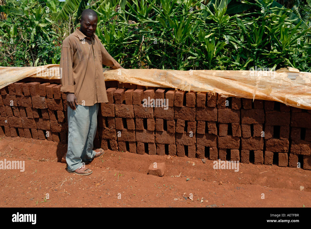 Man showing off bricks being sun dried in Western Kenya at the side of the Kisumu Maseno road in Kenya East Africa Stock Photo