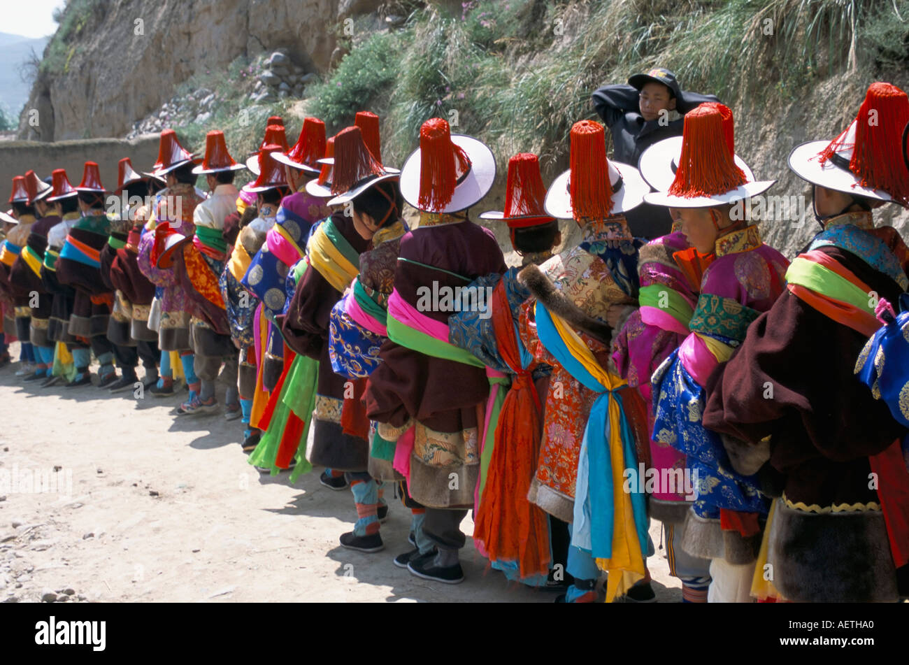 Line of people wearing Tibetan traditional dress Tongren Qinghai ...
