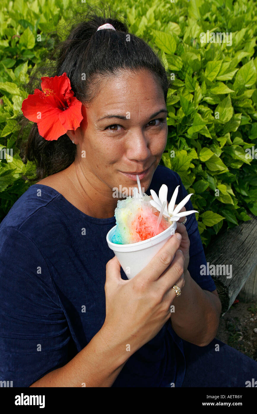 Local woman drinks shave ice popular Hawaiian drink made of crushed ice and flavored syrup Stock Photo