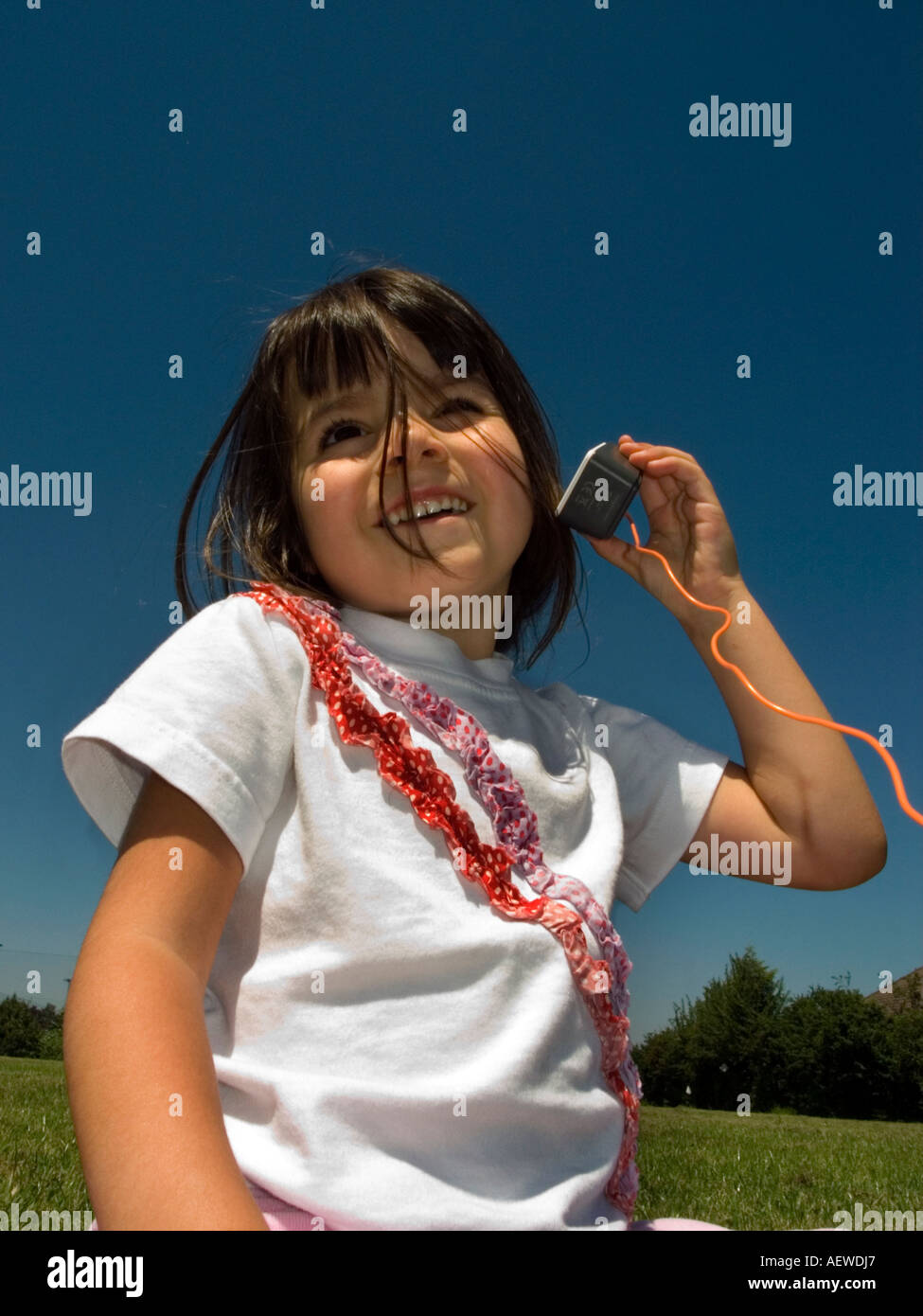 Young girl listening to music on a portable mobile phone Stock Photo