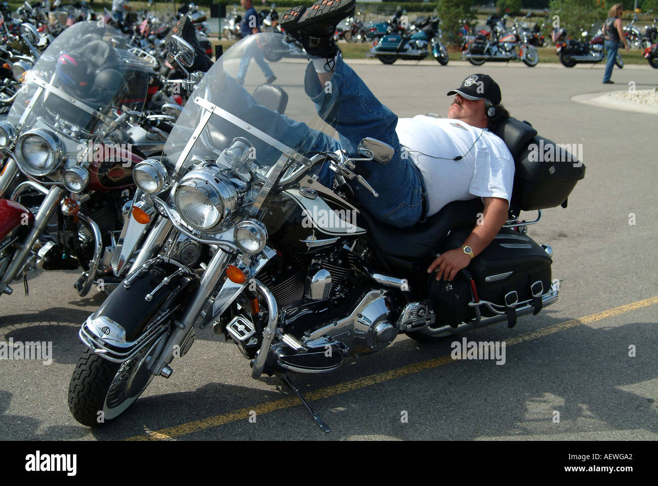 A man resting while lying on his harley davidson motorcycle Stock Photo