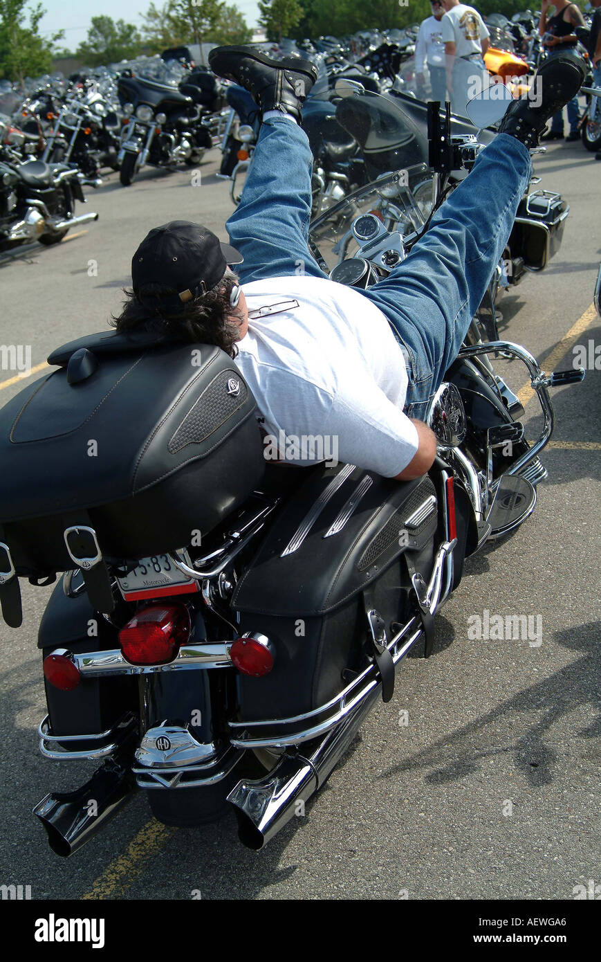A man resting while lying on his harley davidson motorcycle Stock Photo