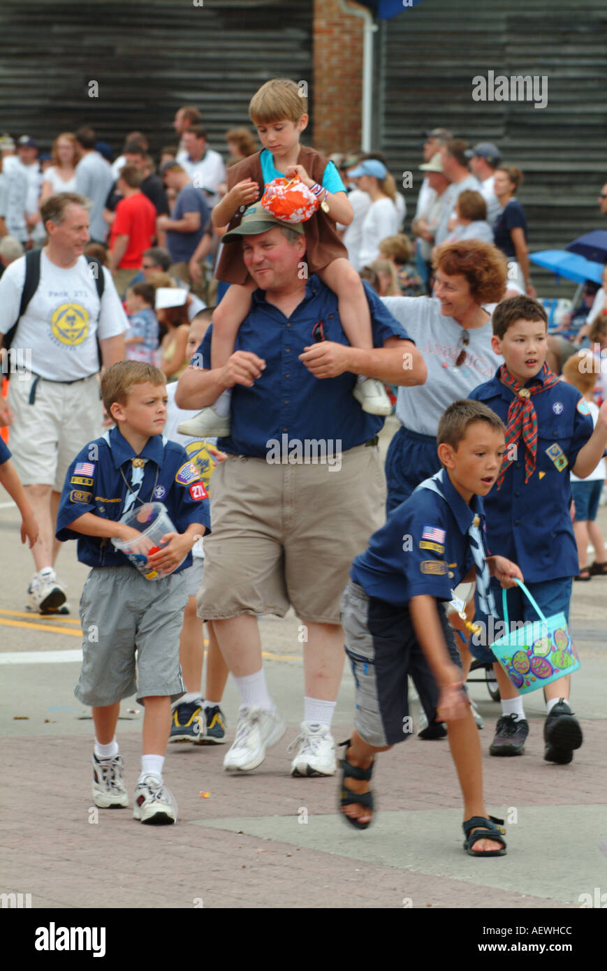 Boy scout kids and master with a kid on his shoulders distributing candies sweets toffees at independence day Stock Photo