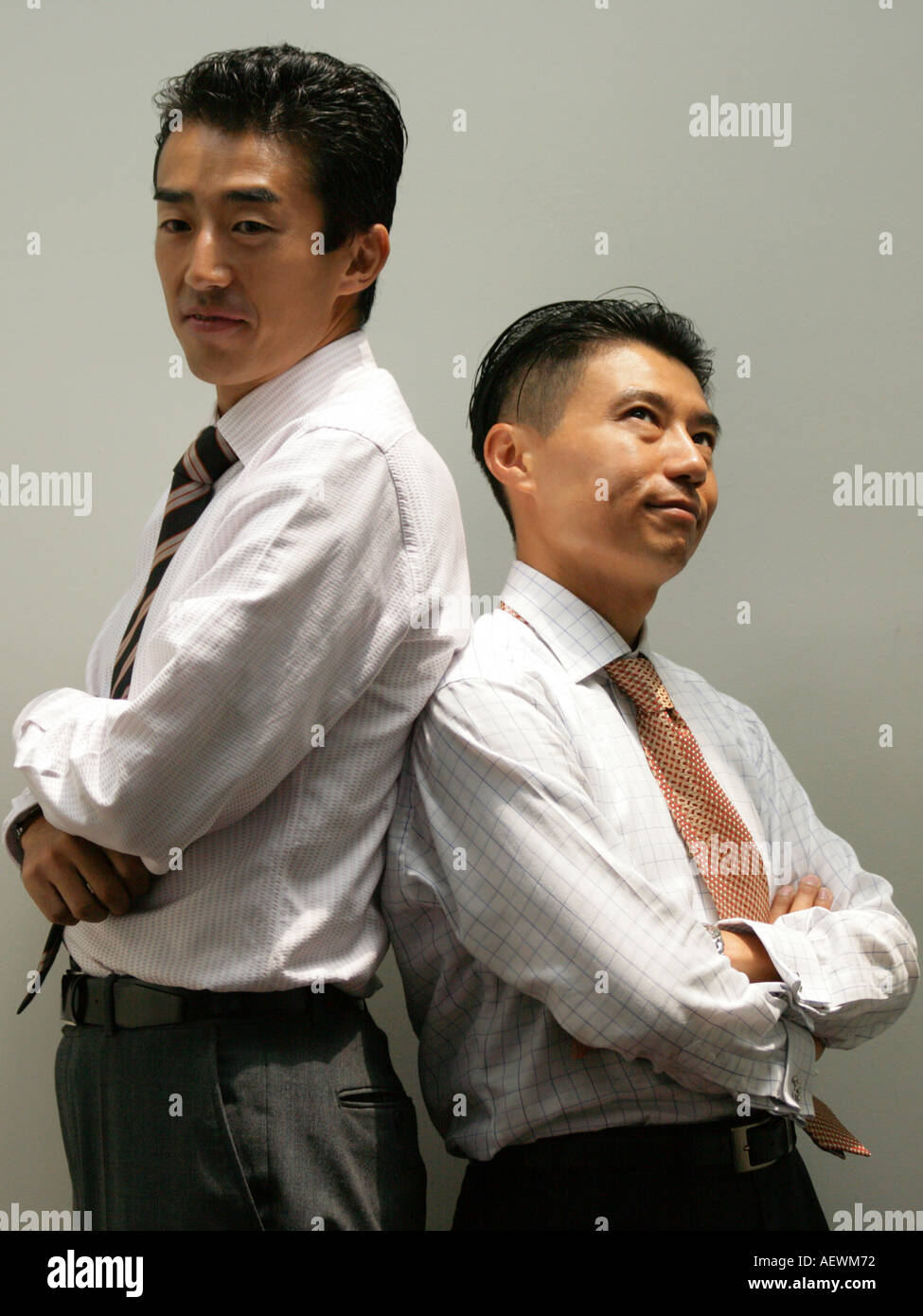 Side profile of two businessmen standing back to back Stock Photo - Alamy