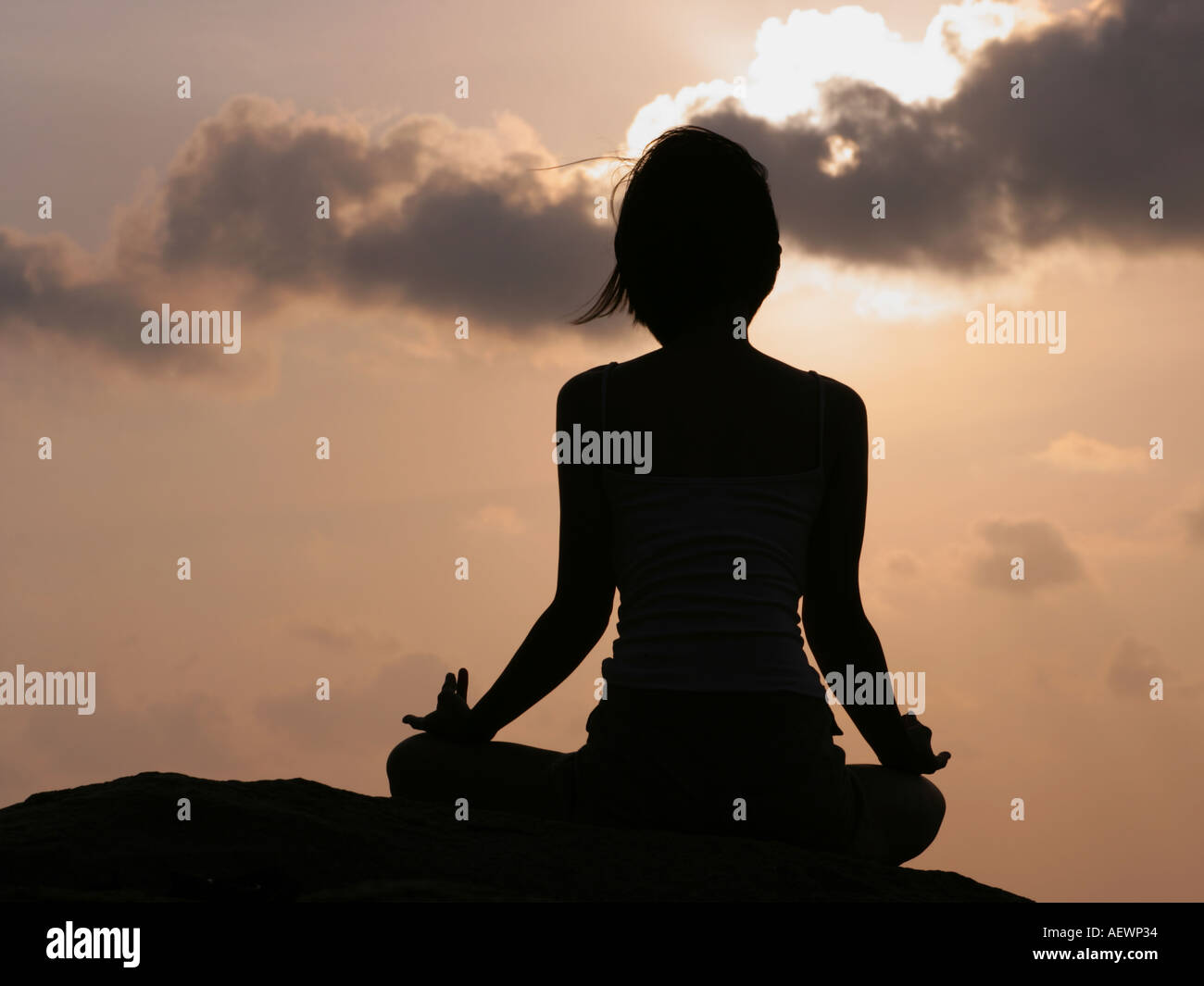 Silhouette of a woman meditating on the beach Stock Photo - Alamy