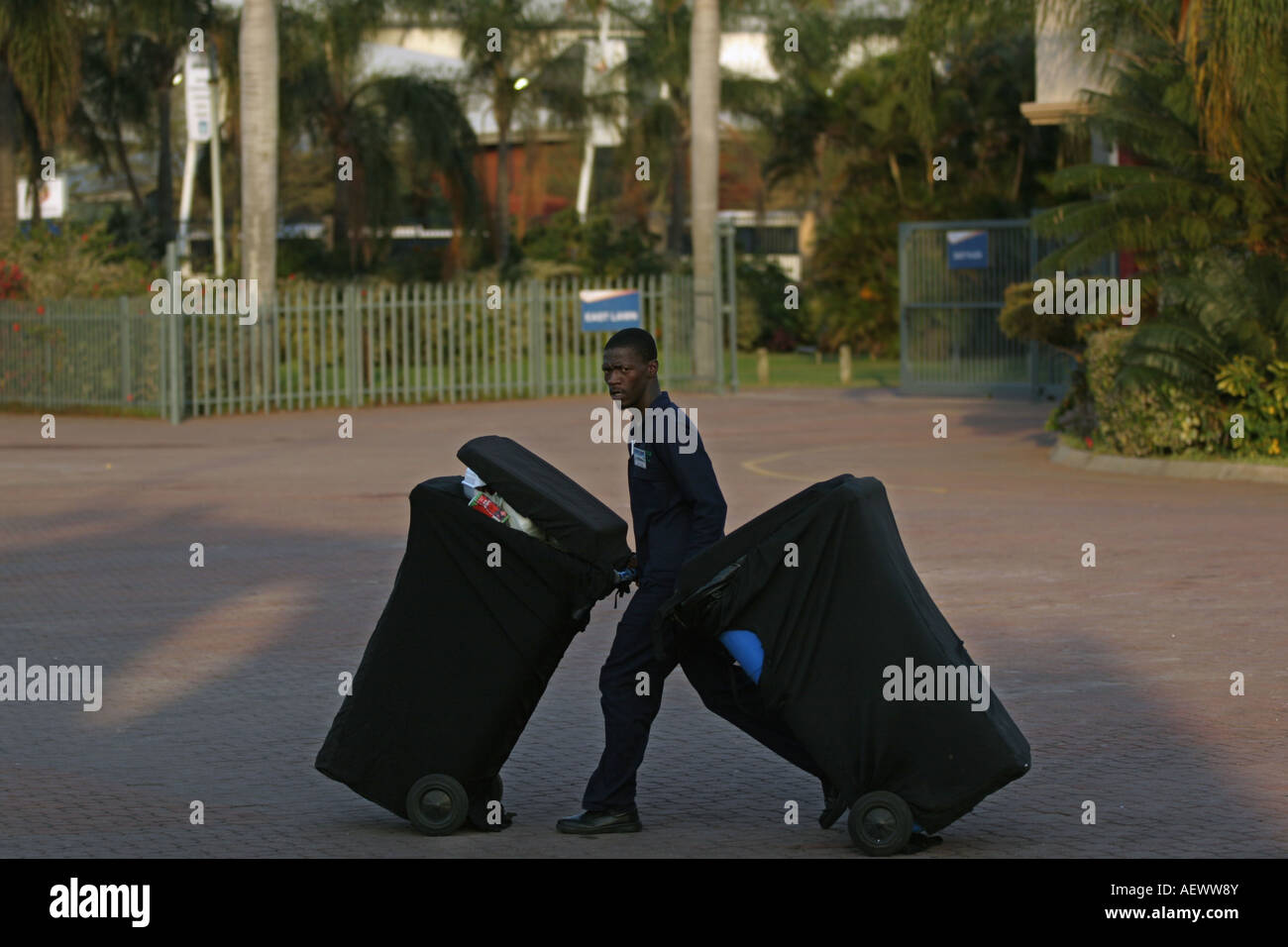 A labourer removes plastic dirt bins, South Africa Stock Photo Alamy