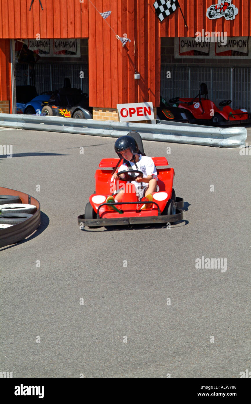 Children Having Fun Driving Go Karts Around A Track At An