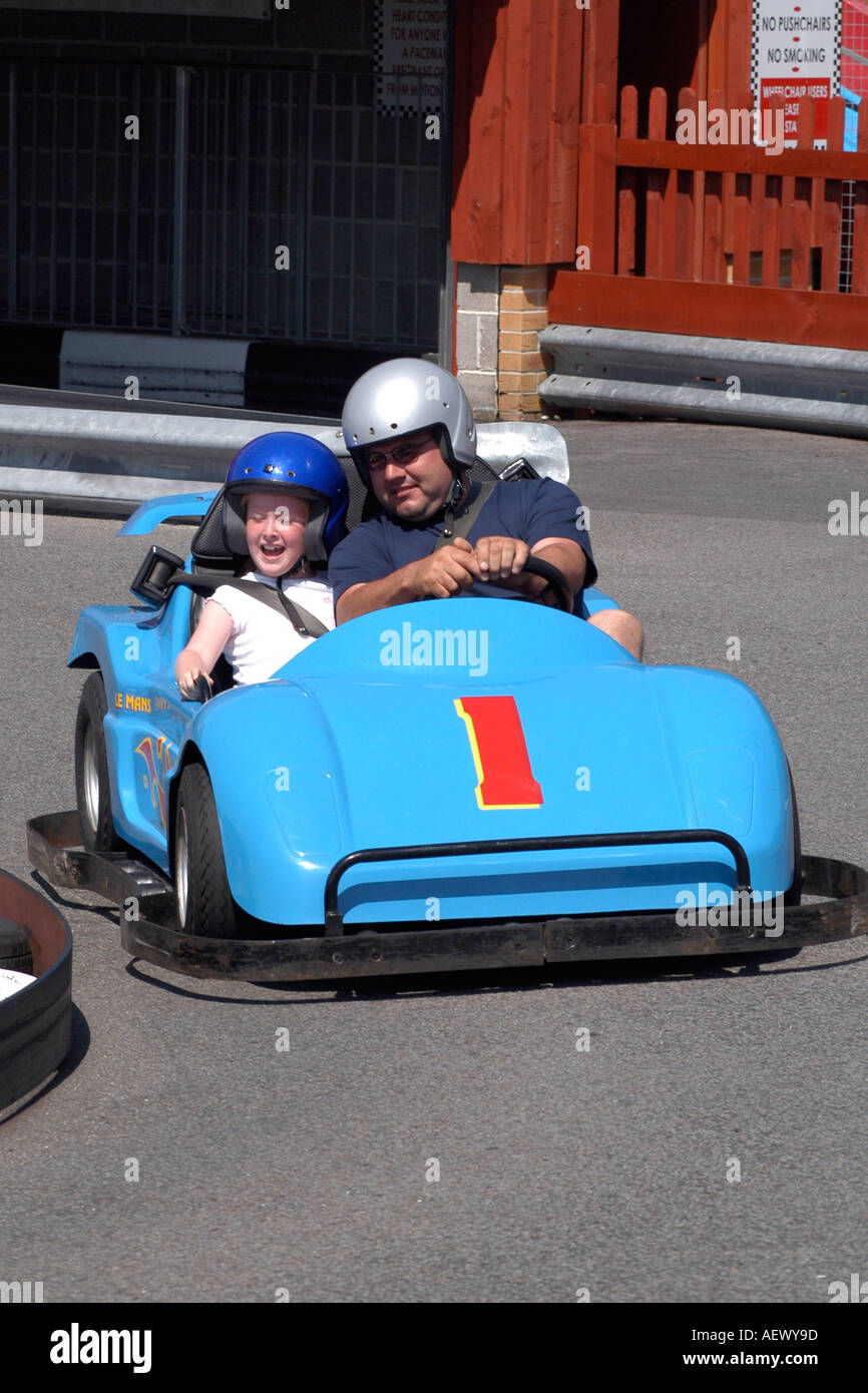 Children Having Fun Driving Go Karts Around A Track At An