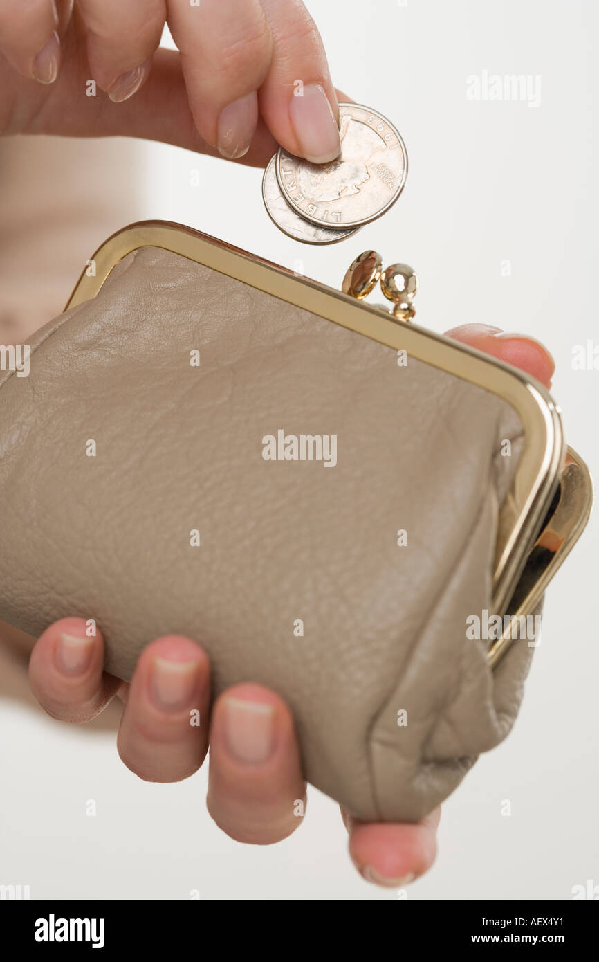 Woman putting change in coin purse Stock Photo Alamy