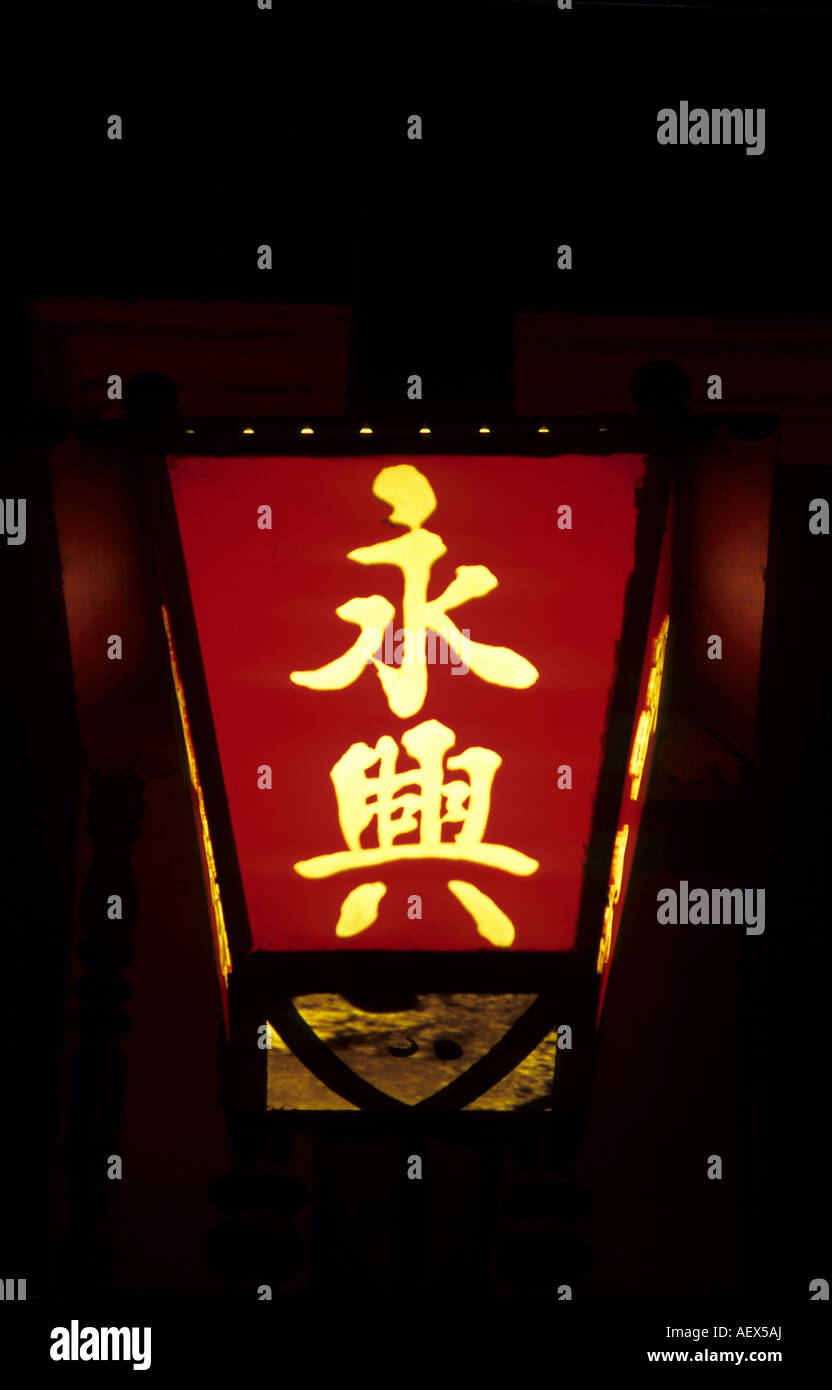 Traditional red lantern with Chinese character calligraphy lit up at night Stock Photo
